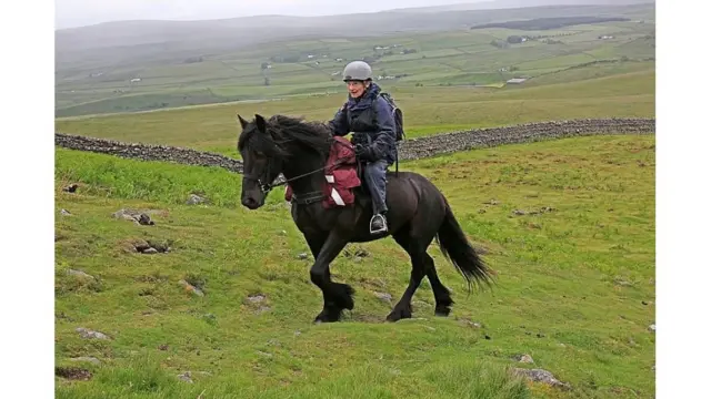 Margaret Bradshaw on horseback in the hills of the Teesdale Valley during her 80-km hike to raise funds